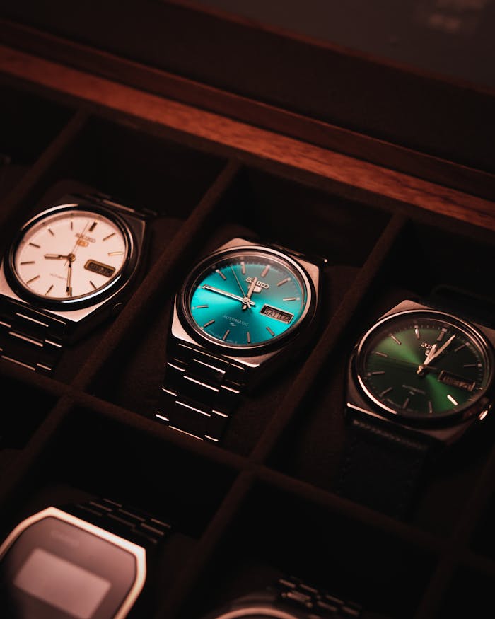 Close-up of luxury wristwatches in a display case with vintage style lighting.